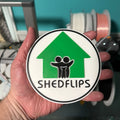 Shed Flips logo magnet, hand held in the shed